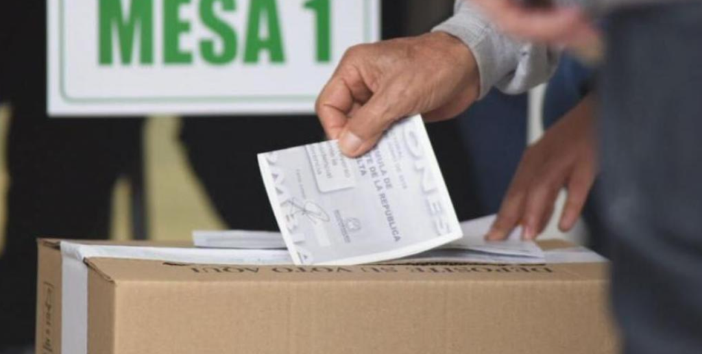 Ciudadano colombiano deposita su voto en la urna donde está hábil para ejercer su derecho al voto